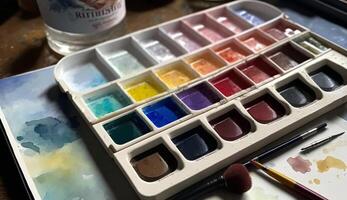 Paintbrush on messy palette with multi colored paints , photo