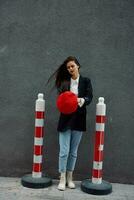 Fashion woman standing on the street in front of the city and road works tourist in stylish clothes with red lips and red beret, travel, cinematic color, retro vintage style, urban fashion. photo