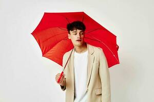 portrait of a young man red umbrella a man in a light jacket isolated background unaltered photo