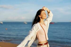 Woman smile freedom on vacation walking on the beach by the ocean in Bali sunset, happy travel and vacation, sunset light photo