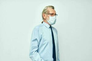 Portrait of happy senior man medical safety mask health light background photo