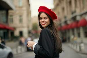 Fashion woman smile with teeth standing on the street in front of the city tourist in stylish clothes with red lips and red beret, travel, cinematic color, retro vintage style, urban fashion. photo