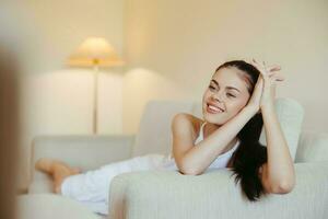 Happy girl smile lying on the couch at home, relaxing at home, comfort, sunshine. photo