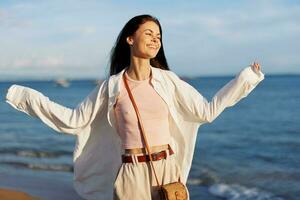 Woman smile freedom on vacation walking on the beach by the ocean in Bali sunset, happy travel and vacation, sunset light photo