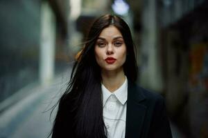 Fashion woman dramatic portrait tourist in stylish clothes in jacket and red beret walking down narrow city street flying hair, travel, French style, cinematic color, retro vintage style. photo