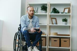 A man in a wheelchair gamer plays games with a joystick in his hands at home, surprise open mouth, copy space, with tattoos on his hands, health concept man with disabilities, real person photo