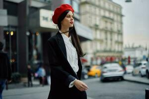 A business woman walks in the city against the backdrop of office buildings, stylish fashionable clothes and make-up, spring walk, travel. photo