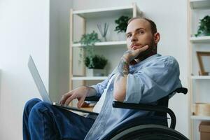 hombre en silla de ruedas persona de libre dedicación trabajando a ordenador portátil a hogar sonrisa, trabajando en línea, social redes y puesta en marcha, Copiar espacio, social integración, salud concepto hombre con discapacidades, real persona foto