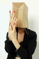 portrait of a woman with a bag on his head in a black jacket red nail polish Lifestyle unaltered photo