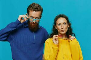 A woman and a man fun couple cranking and showing signs with their hands smiling cheerfully, on a blue background, The concept of a real relationship in a family. photo