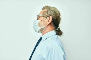 Portrait of happy senior man in shirt with tie medical mask safety light background photo