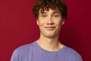 funny curly-haired guy in a purple t-shirt gestures with his hands photo