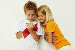 Cute preschool kids fun in colorful t-shirts with a notepad color background unaltered photo