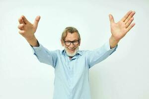 old man in blue shirts gestures with his hands isolated background photo