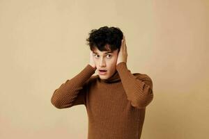 handsome guy stylish hairstyle brown turtleneck light background unaltered photo