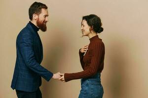 Man and woman couple in a relationship smile and interaction on a beige background in a real relationship between people photo