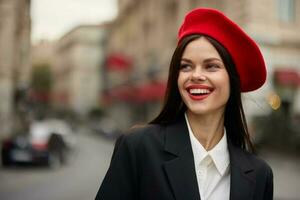 Fashion woman portrait smile teeth standing on the street in the city background in stylish clothes with red lips and red beret, travel, cinematic color, retro vintage style, urban fashion lifestyle. photo