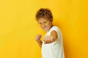 Cute little boy in a white T-shirt with glasses gesturing with his hands lifestyle unaltered photo