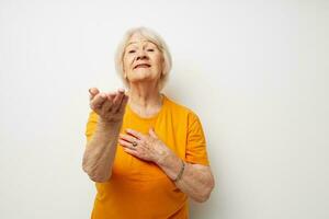 Photo of retired old lady in a yellow t-shirt posing close-up emotions