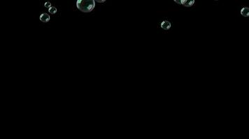 volador jabón burbujas un lote de jabón burbujas mosca a través de el pantalla. burbujas que cae abajo en negro antecedentes. video