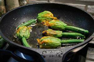 Pan-roasted zucchini flowers or zucchini with parmesan cheese in a casserole, Italian appetizer photo