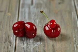 Nature's Oddity ugly, irregularly shaped cherry stands out against a rustic wooden backdrop photo
