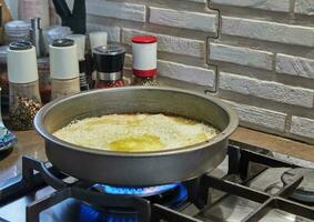 Sugar is fried in frying pan with oil on gas stove photo