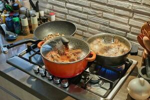 Pots with cooking food in the kitchen on gas stove photo