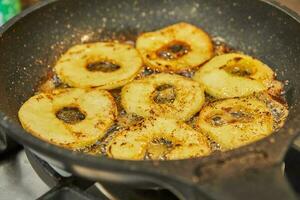 rebanado manzanas son frito en pan en gas estufa foto