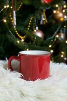 blanco rojo jarra con Navidad árbol en fondo, te o café taza con Navidad y nuevo año decoración,horizontal burlarse de arriba con cerámico jarra para caliente bebidas, vacio regalo impresión modelo foto