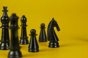 negro conjunto de ajedrez cifras en competencia éxito jugar. estrategia, administración o liderazgo concepto en amarillo antecedentes foto