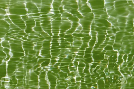 Blue water with ripples on the surface. Defocus blurred transparent blue colored clear calm water surface texture with splashes and bubbles. Water waves with shining pattern texture background. photo