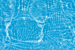 Blue water with ripples on the surface. Defocus blurred transparent blue colored clear calm water surface texture with splashes and bubbles. Water waves with shining pattern texture background. photo