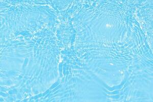 Blue water with ripples on the surface. Defocus blurred transparent blue colored clear calm water surface texture with splashes and bubbles. Water waves with shining pattern texture background. photo