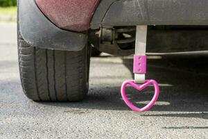 pink heart hanging on a rope on the back of the car photo