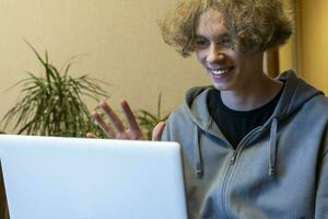 A young guy is chatting in a video chat via a laptop. video call. photo