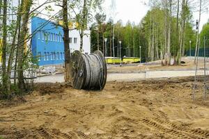 wooden coil with an electric cable is lying on a construction site photo