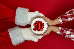 de santa manos dar regalos a niños a Navidad. rojo antecedentes foto