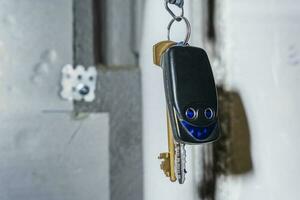 a bunch of keys and a keychain with buttons hang on a hook photo