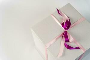 large white gift box tied with a red ribbon on a white background photo