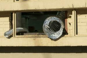 Flexible aluminum foil duct at the window. corrugated exhaust hose photo