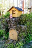 a tree stump with a gate stylized as a house of a forest squirrel photo