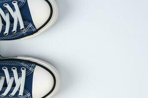 un par de azul zapatillas en un blanco antecedentes. de moda juventud Zapatos foto