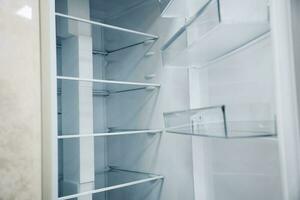 vacío estantería de un abierto refrigerador. un nuevo refrigerador foto