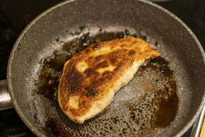 Homemade fried chebureks with meat in a frying pan photo