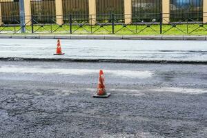 blanco-naranja tráfico conos en el ciudad autopista durante la carretera refacción foto