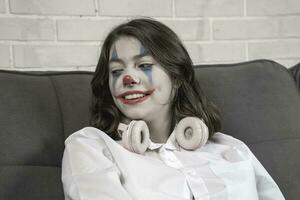 a teenage girl with clown makeup talks about something emotionally photo