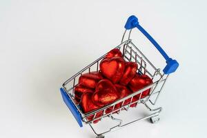 Supermarket trolley loaded with heart shaped candies photo