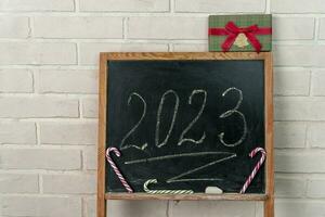 a black slate on which the year 2023 is written in chalk. Happy New Year. photo