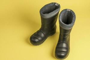 children's warm rubber boots on a yellow background. gray rubber boots photo